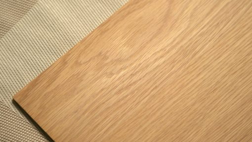 塗裝水性木器透明漆SOWARD的塗裝板放置於卡其色布面上，木板上木紋清晰可見。