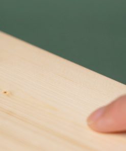 橄欖綠背景，一片塗裝木器還原漆WOODLIKE的實木木板，一根手指滑過木頭的塗膜平滑表面。